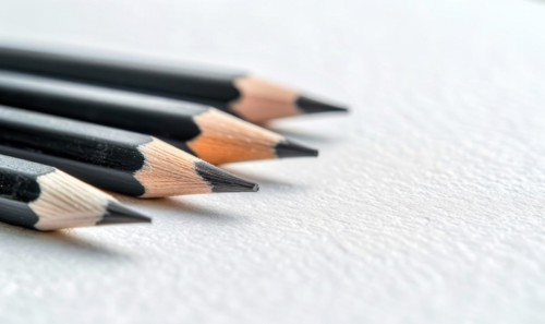 Graphite pencils lying on a blank sheet of white paper AI generated