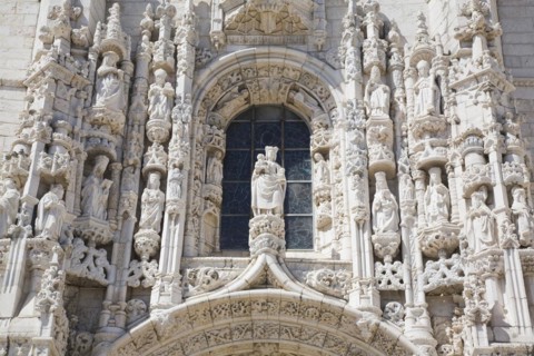 Arched window with decorated carved sculptures on facade of Jeronimos Monastery, Lisbon, Portugal,