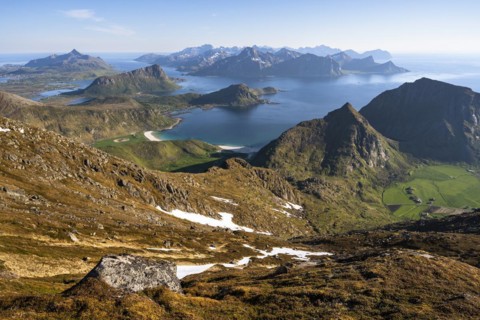 Landscape with sea and mountains. Descent from Himmeltindan mountain. View of the light-coloured