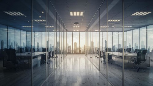 Modern office with glass walls, sunset light casting reflections, and view of skyscrapers,