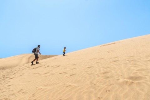 Father and son very happy in the dunes of Maspalomas, Gran Canaria, Canary Islands