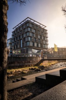 Ibis Styles Hotel, Modern architecture with reflection in a puddle, captured in daylight, sunrise,