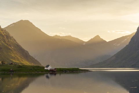 Landscape with sea and mountains on the Lofoten Islands. The fjord Flakstadpollen and some houses