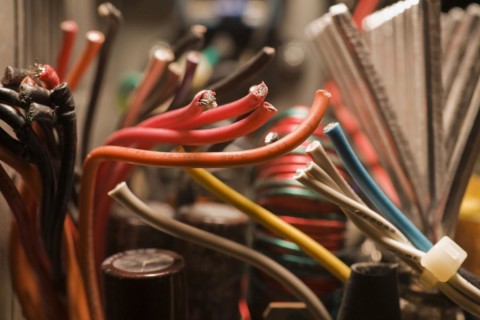 Close-up of cut black, red, yellow, blue and white flexible insulated electrical copper wires,