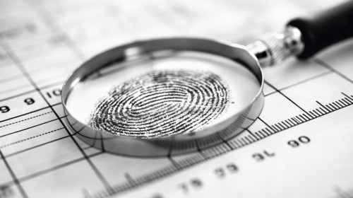 Magnifying glass resting on a fingerprint on paper. generative AI, AI generated