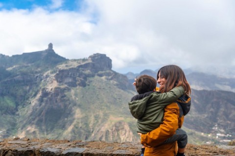 A mother with her son looking at Roque Nublo from a viewpoint. Gran Canaria, Spain, Europe