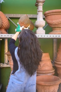 Woman selecting a terracotta ornament in a pottery studio