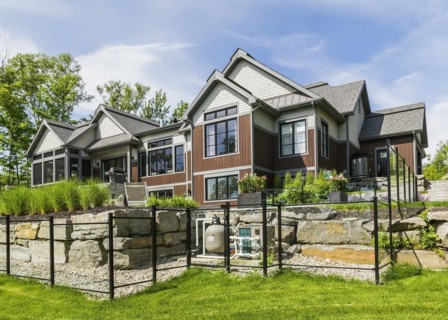 Rear view of contemporary natural stone and brown stained wood and cedar shingles clad luxurious