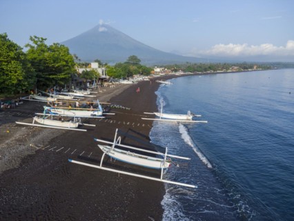 Fishermen loading fish from their outrigger boats in the morning on the black beach of Amed, Amed,