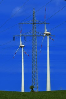 Power pylon with high-voltage lines and wind turbines at the Avacon substation Helmstedt,