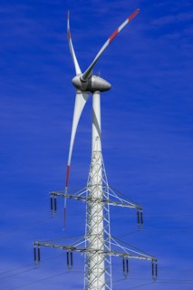 Electricity pylon with high-voltage lines and wind turbine at the Avacon substation Helmstedt,