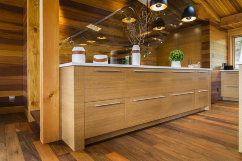 Bamboo wood buffet with white quartz countertop illuminated by black industrial style pendant