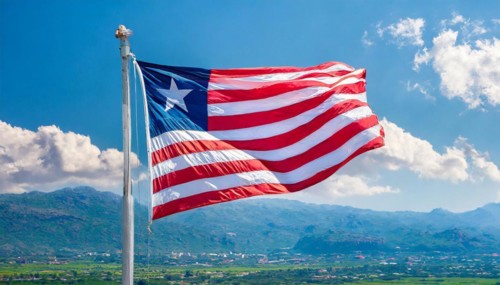 The flag of Liberia, fluttering in the wind, isolated, against the blue sky