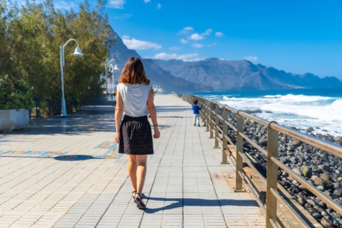 A woman strolling along the promenade in Agaete in Puerto de Las Nieves in Gran Canaria, Spain,
