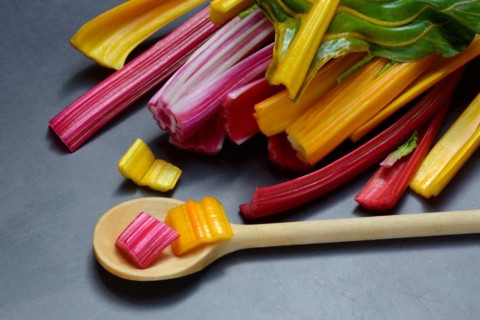 Red and yellow chard, wooden spoon and chopped stems, Beta vulgaris