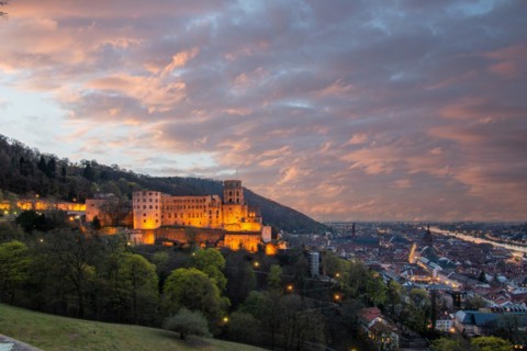 View over an old town with castle or palace rune in the evening at sunset. This town lies in a