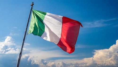 The flag of Italy flutters in the wind, isolated against a blue sky