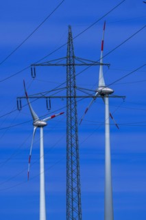 Power pylon with high-voltage lines and wind turbines at the Avacon substation Helmstedt,
