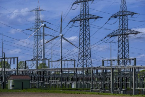 Power pylons with high-voltage lines and wind turbines at the Avacon substation in Helmstedt,