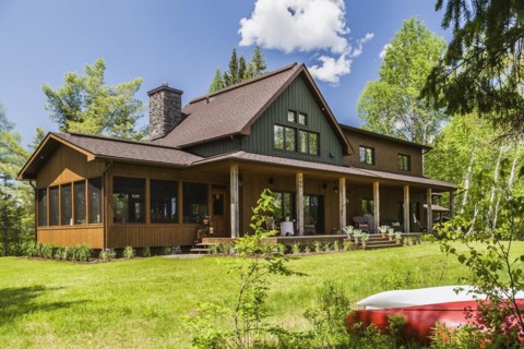 Rear view of brown and green stained spruce wood and cedar shingle siding LEED certified Country