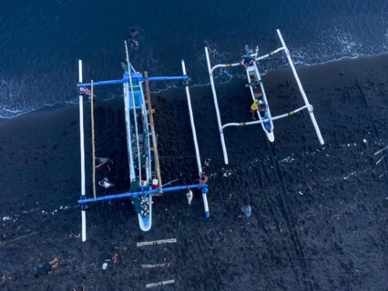 Fishermen unload their catch from their outrigger boat in the morning. Amed, Karangasem, Bali,