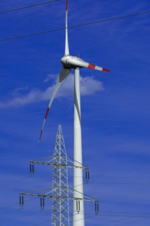 Electricity pylon with high-voltage lines and wind turbine at the Avacon substation Helmstedt,
