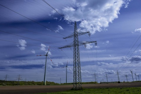 Power pylons with high-voltage lines and wind turbines at the Avacon substation in Helmstedt,