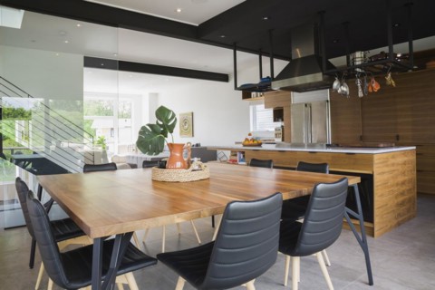 American walnut wood dining table and black leather sitting chairs with ash wood legs in dining