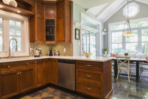 Kitchen with cherry wood cabinets, earth tone slate flooring and wooden breakfast table with