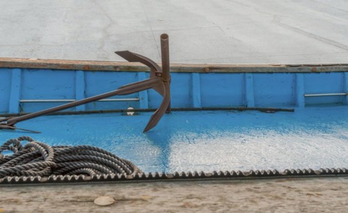 Anchor and rope laying on deck of dry docked fishing boat in South Korea