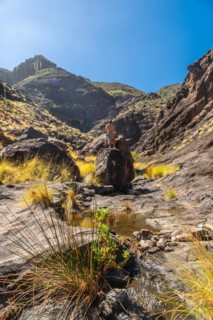 A hiker on the river on the climb to Charco Azul in the Podemos to Agaete in Gran Canaria, Canary