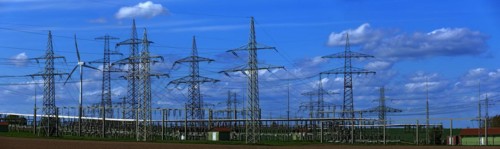 Power pylons with high-voltage lines and wind turbines at the Avacon substation in Helmstedt,