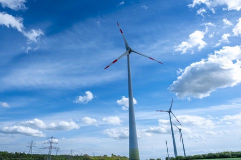 Power pylons with high-voltage lines and wind turbines near the Avacon substation Helmstedt,