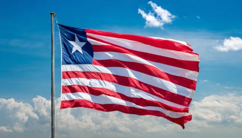 The flag of Liberia, fluttering in the wind, isolated, against the blue sky