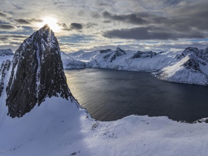 Aerial view of Bergen by the sea, fjord, sunbeams, winter, snow, Mount Segla, Senja, Troms, Norway,