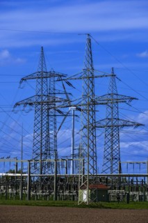 Power pylons with high-voltage lines and wind turbine at the Avacon substation in Helmstedt,