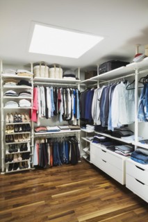 Walk-in his and hers closet with skylight window, American walnut flooring on upstairs floor inside