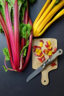 Swiss chard, chopped stems on wooden board with knife, Beta vulgaris
