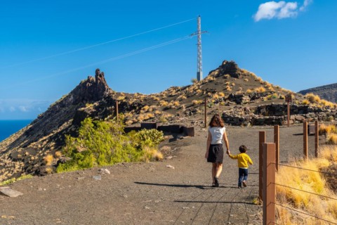 A mother and her son walking along the rock formation on the coast of Agaete, Roque Guayedra, Gran