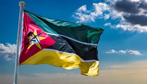 The flag of Mozambique, fluttering in the wind, isolated, against the blue sky