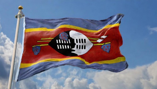 The flag of Swaziland, Kingdom of Eswatini, flutters in the wind, isolated, against the blue sky