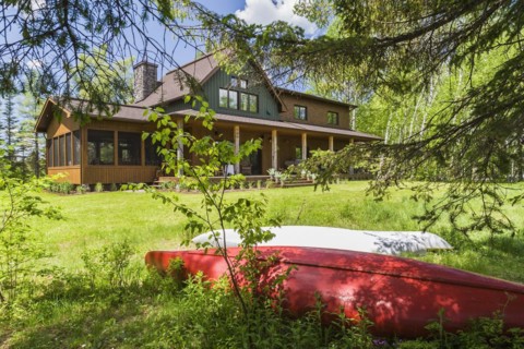 Rear view of brown and green stained spruce wood and cedar shingle siding LEED certified Country