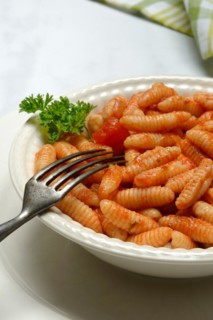Malloreddus, Sardinian gnocchetti with tomato sauce in a plate, traditional pasta variety from
