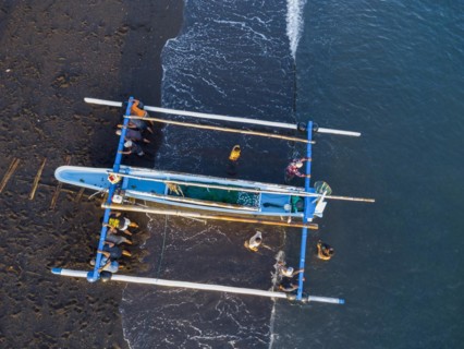 Fishermen loading fish from their outrigger boats in the morning on the black beach of Amed, Amed,