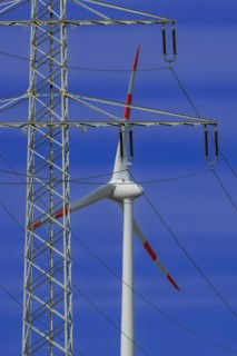 Power pylon with high-voltage lines and wind turbines at the Avacon substation Helmstedt,