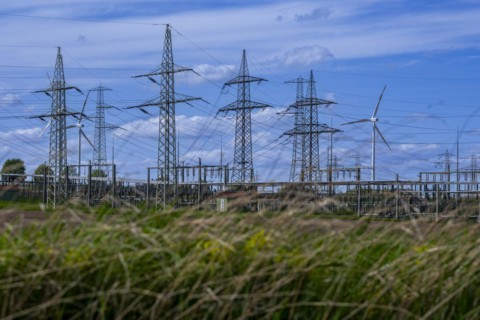 Power pylons with high-voltage lines and wind turbines at the Avacon substation in Helmstedt,