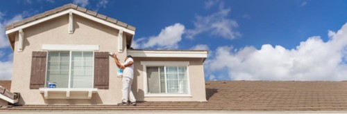 Banner of busy house painter painting the trim and shutters of A home