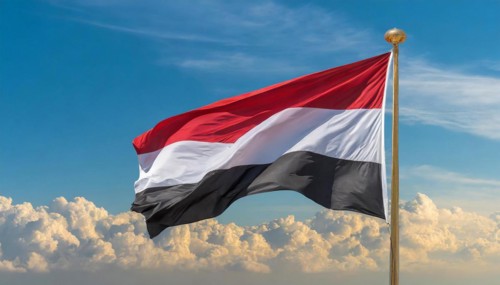 The flag of Yemen, fluttering in the wind, isolated, against the blue sky