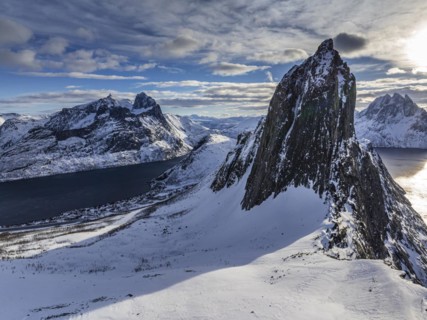 Aerial view of Bergen by the sea, fjord, sunbeams, winter, snow, Mount Segla, Senja, Troms,
