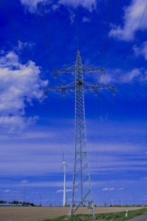 Power pylons with high-voltage lines and wind turbines at the Avacon substation in Helmstedt,